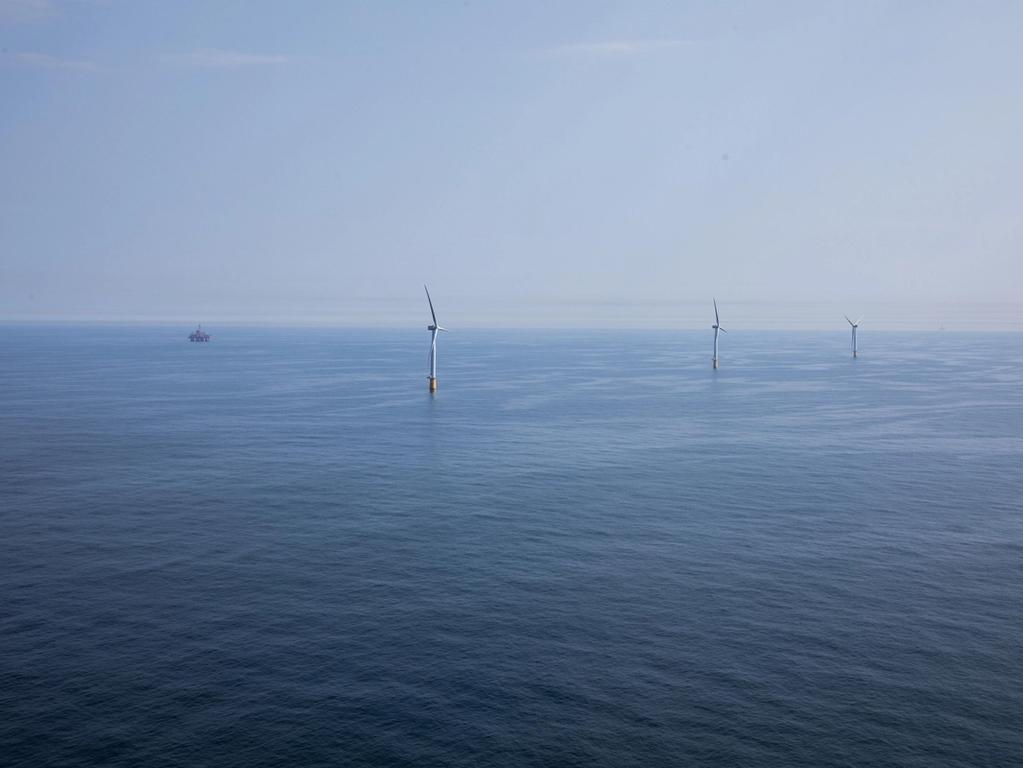 Photo of offshore oil platform and wind turbines at Hywind Tampen