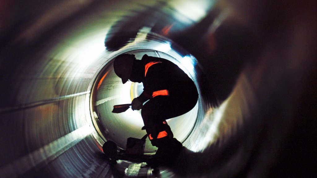 Photo of worker inspecting inside a pipe